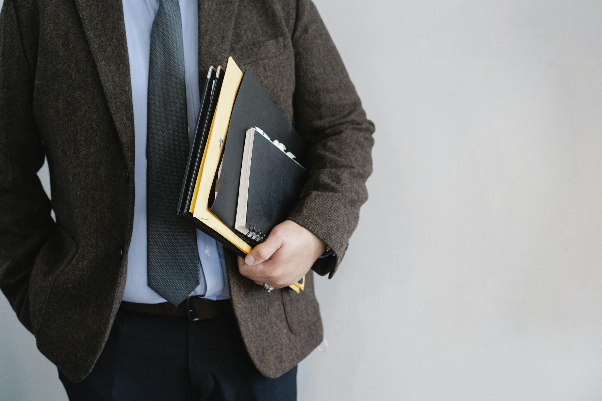 Crop unrecognizable office worker standing with papers in hand